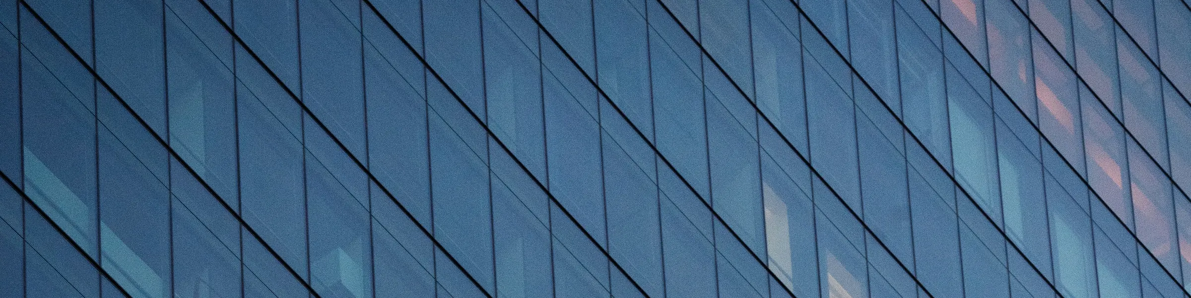 Illustrative photograph: a blue glass office facade