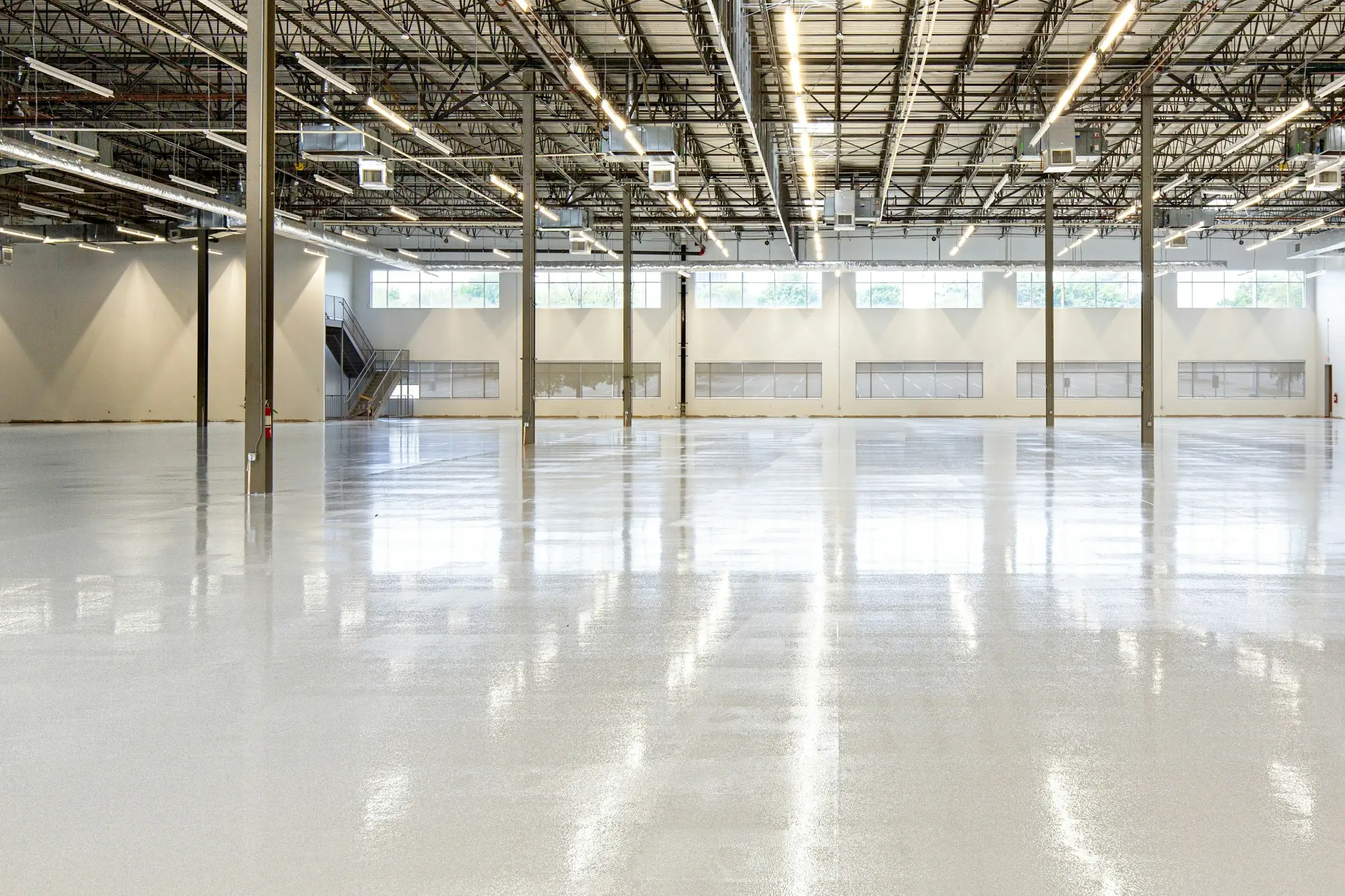 Illustrative photograph: a large empty floor with a freshly sealed, reflective finish