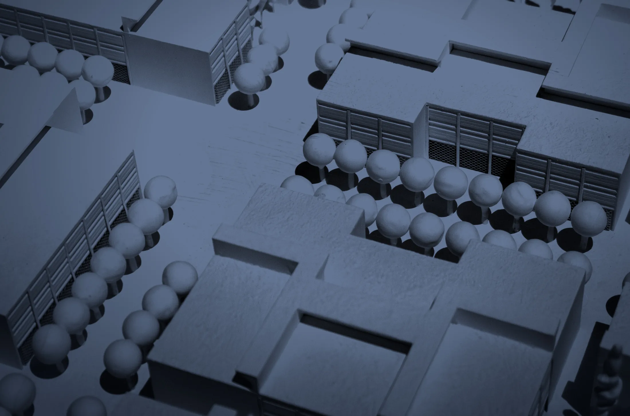 Illustrative photograph: a white architectural model of office buildings, at night